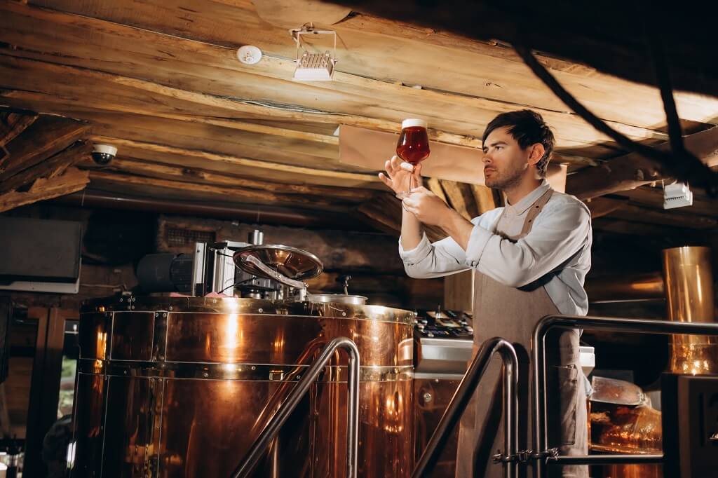 Pivar u zanatskoj pivari proverava kvalitet piva tokom procesa proizvodnje