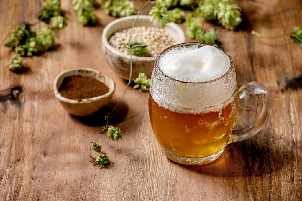 Krigla IPA piva sa hmeljem i sastojcima na drvenoj površini